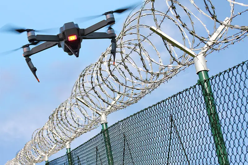 drone flying over wire fence indicating a security application